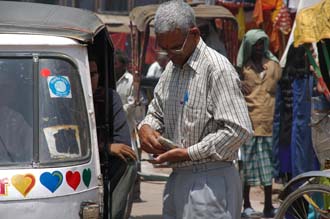 VNS Varanasi or Benares - man paying the autorickshaw taxi driver outside Durga Temple 3008x2000