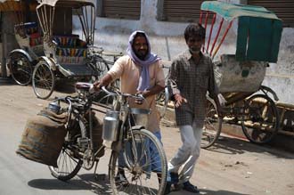 VNS Varanasi or Benares - men with bike transporting heavy water bottles 3008x2000