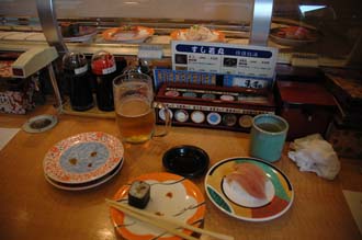 KIX Kyoto - kaiten-zushi or automatic sushi place where the sushi is served on a conveyor belt that runs along a counter 3008x2000